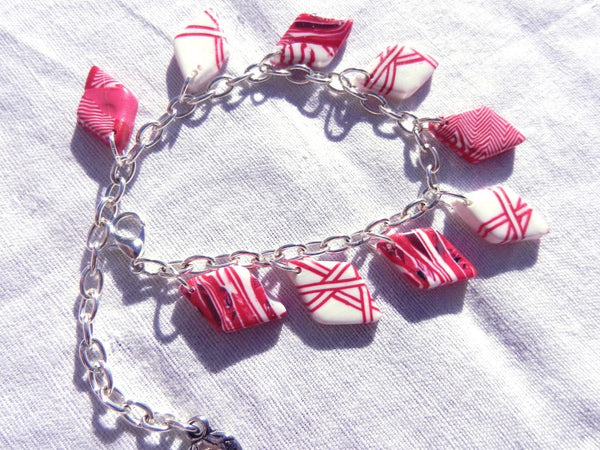 Bracelet losanges et breloque fraise ou chat, rouge et blanc